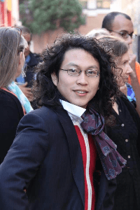 Joseph, a skilled Massage Therapist, demonstrating a movement technique in a dance-inspired wellness session, offering bodywork and somatic healing.