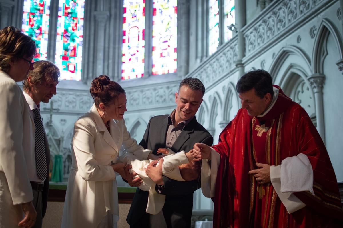 une jolie famille réuni autour du baptéme du nouveau né