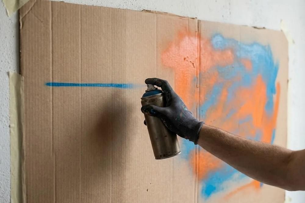 Comparaison d'un trait fin et d'un aplat large peints à la bombe sur carton