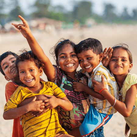 Group of five children smiling together, expressing joy and happiness.