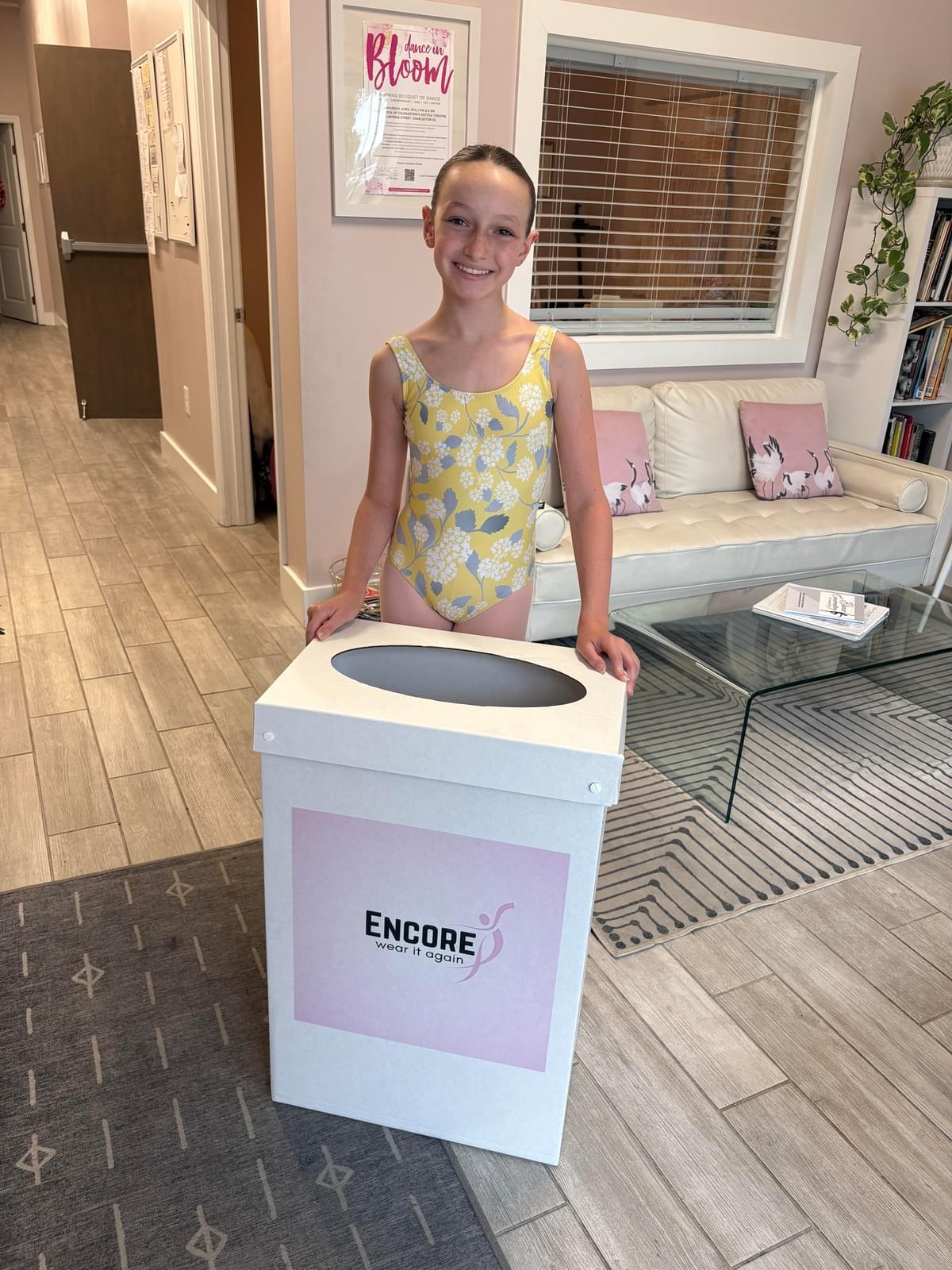 At Encore, we believe in the power of community and sharing. Our initiative not only provides gently used dancewear to those in need but also promotes sustainability by reducing waste. Every donation helps a dancer continue their passion without the financial burden of new gear. Community Impact What We Do What is Encore?
Encore is a community service initiative started by June Ella Hyams when she was in the 6th grade.  Beautifully designed donation boxes are housed at dance studios throughout the Charleston, South Carolina area.  Lightly used or new dancewear, athletic wear, and shoes are donated to the boxes, and once the box is near full, we collect, clean, and ship the items to those in need.

How did Encore begin?
June Ella noticed that she was growing quickly out of her new dancewear and her mother noticed she had even outgrown some dancewear that still had tags on them before she got the chance to wear them.  This became the idea of sharing these clothes with other dancers.  Dancewear can be expensive, so this program helps to ease the financial burden for growing dancers as well as putting the dancewear back into good use for their own "encore".