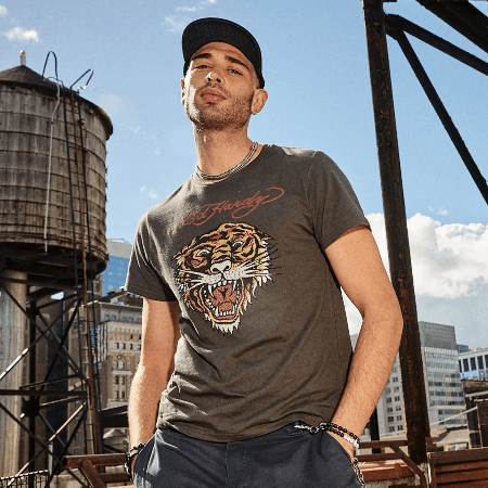Ed Hardy men's olive grey roaring tiger graphic t-shirt worn on NYC rooftop with black snapback cap.