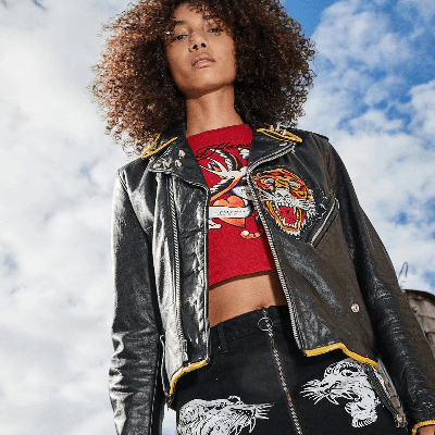 Close-up of a woman in a black studded leather jacket over a red Ed Hardy tiger and swallow graphic top. Close-up of a woman in a black studded leather jacket over a red Ed Hardy tiger and swallow graphic top.