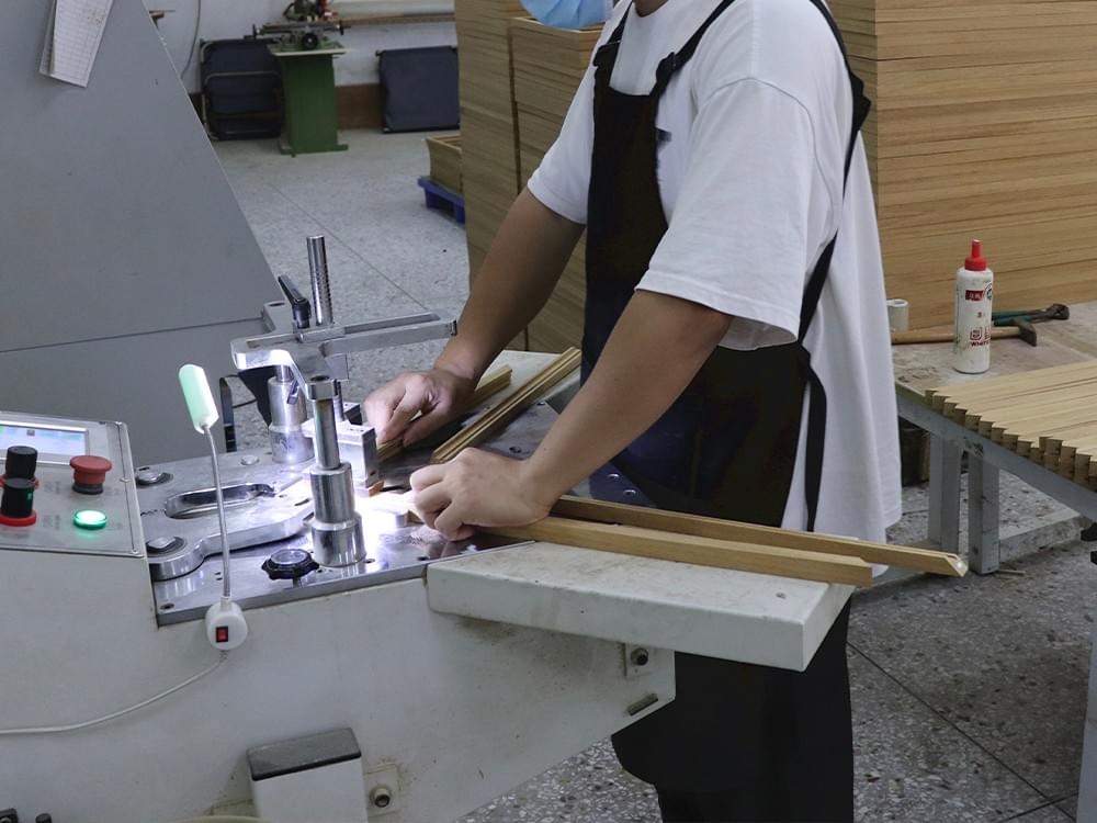 Worker joining mitered solid wood picture frame corners during production Worker joining mitered solid wood picture frame corners during production
