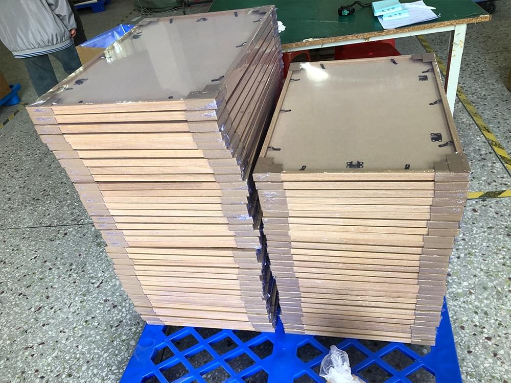 Solid wood picture frames with backing boards stacked for bulk production Solid wood picture frames with backing boards stacked for bulk production