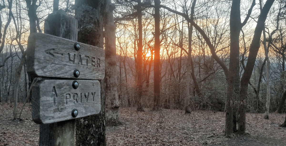 Appalachian Trail sign at sunset pointing to Springer Mountain, Georgia, where John's section hike began