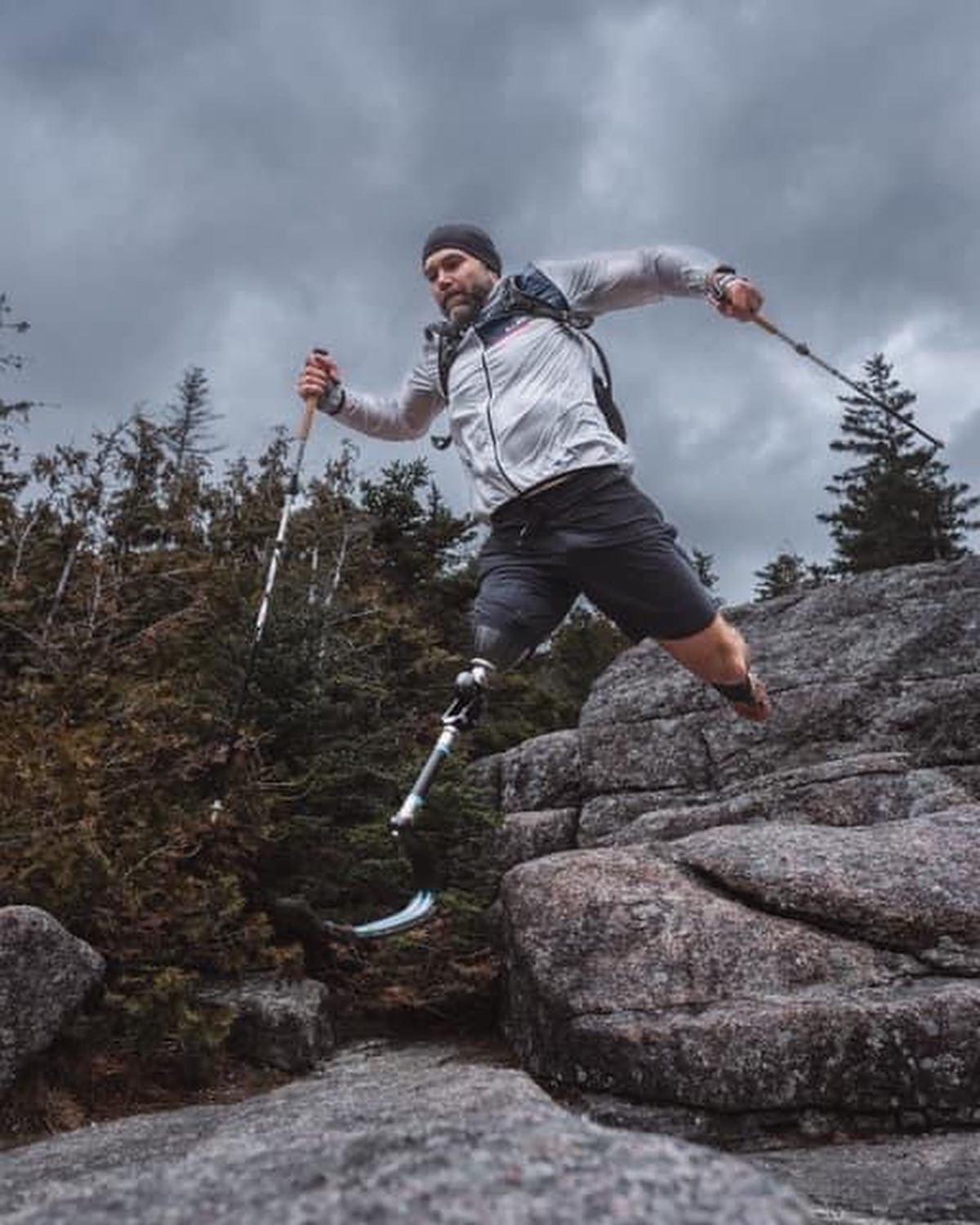 Dan Kosick, above-knee amputee, leaping across granite with trekking poles
