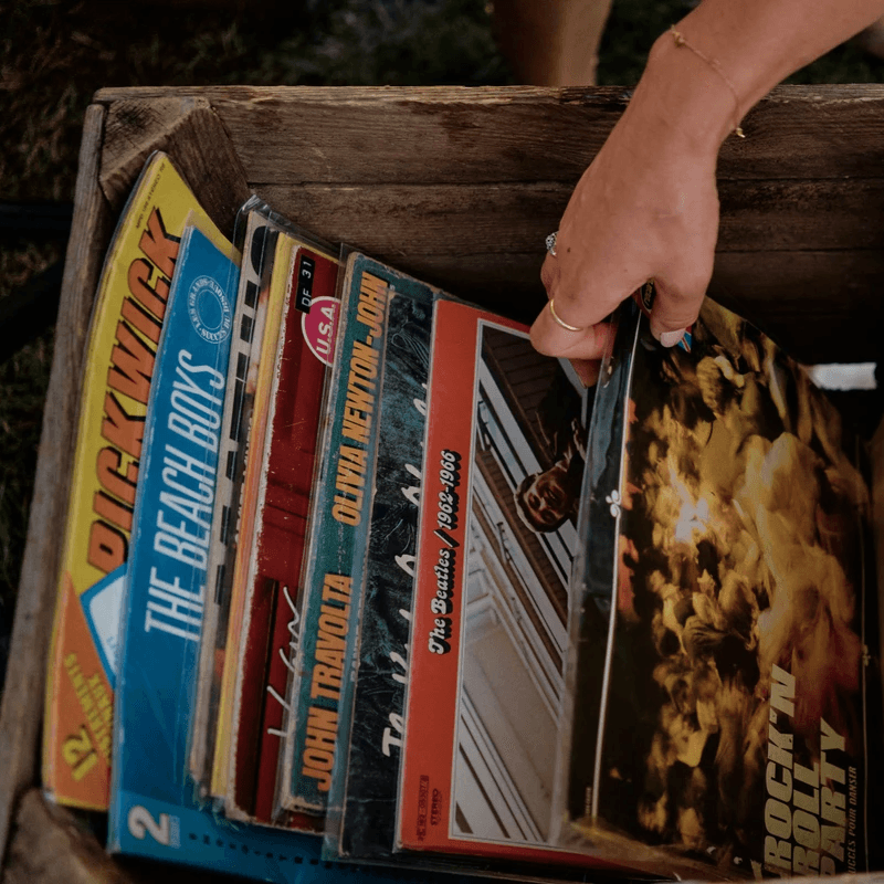 Main piochant dans une caisse contenant des vinyles