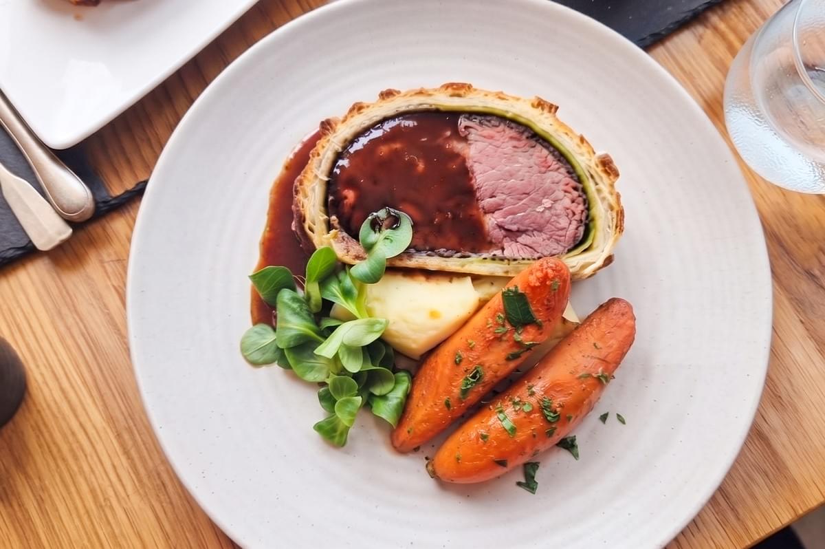 Gordon Ramsay's signature Beef Wellington with red wine jus, roasted carrots, and side greens at Bread Street Kitchen Marina Bay Sands.
