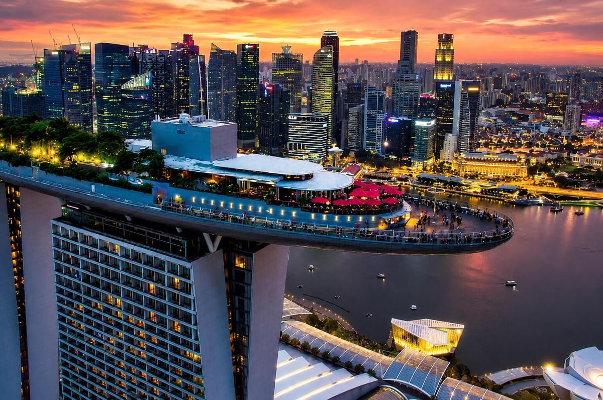 Marina Bay Sands hotel and the lotus-shaped ArtScience Museum reflected on the water at dusk in Singapore.