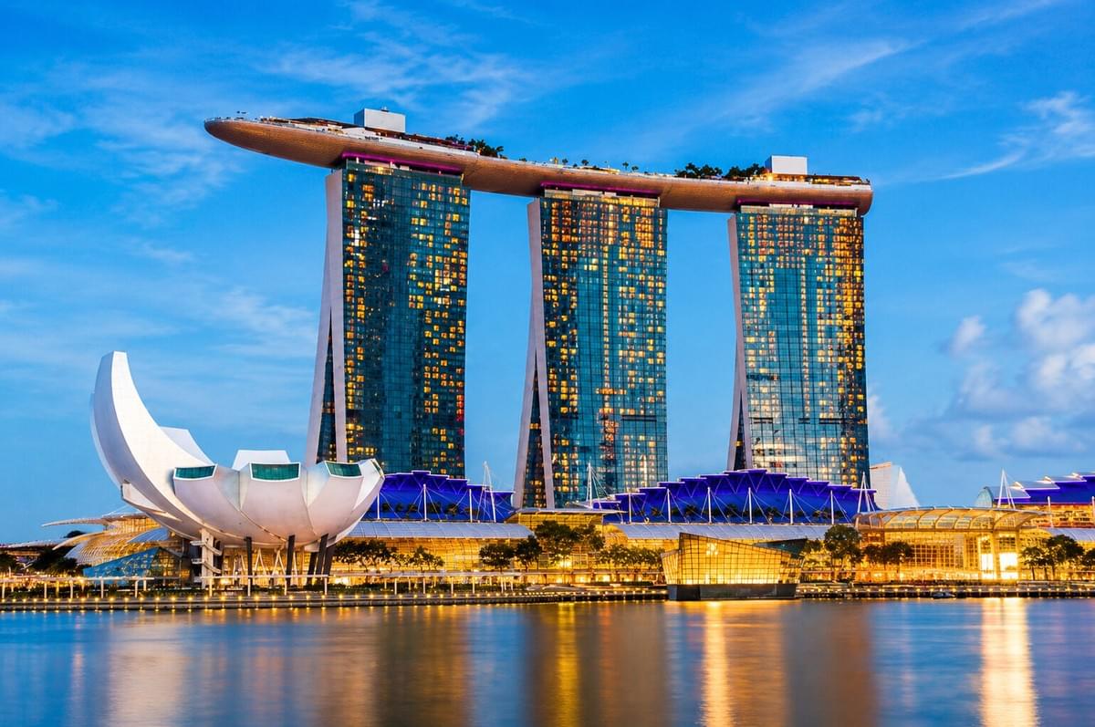 Sunset over the Singapore skyline featuring the Marina Bay Sands rooftop garden and observation deck.