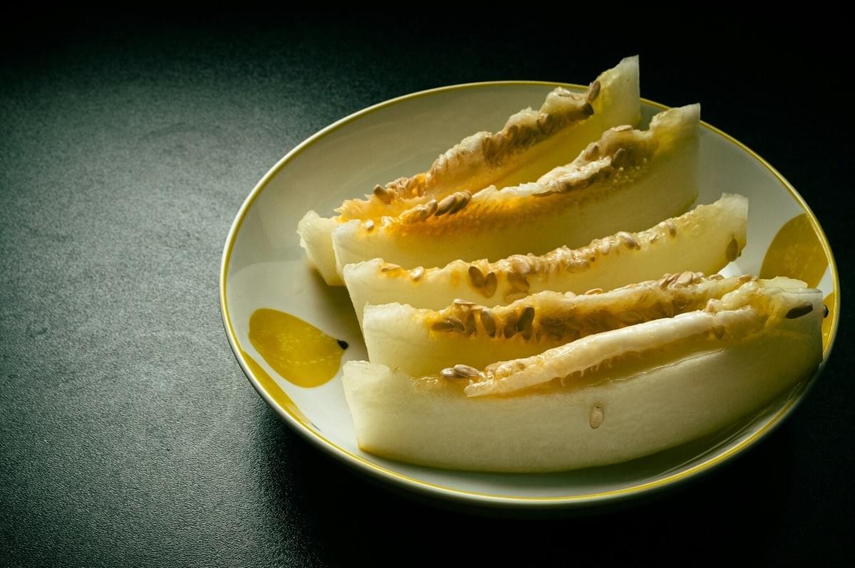 Freshly sliced melon arranged on a plate, emphasizing its nutritional value in the context of melon seeds and egusi soup benefits.