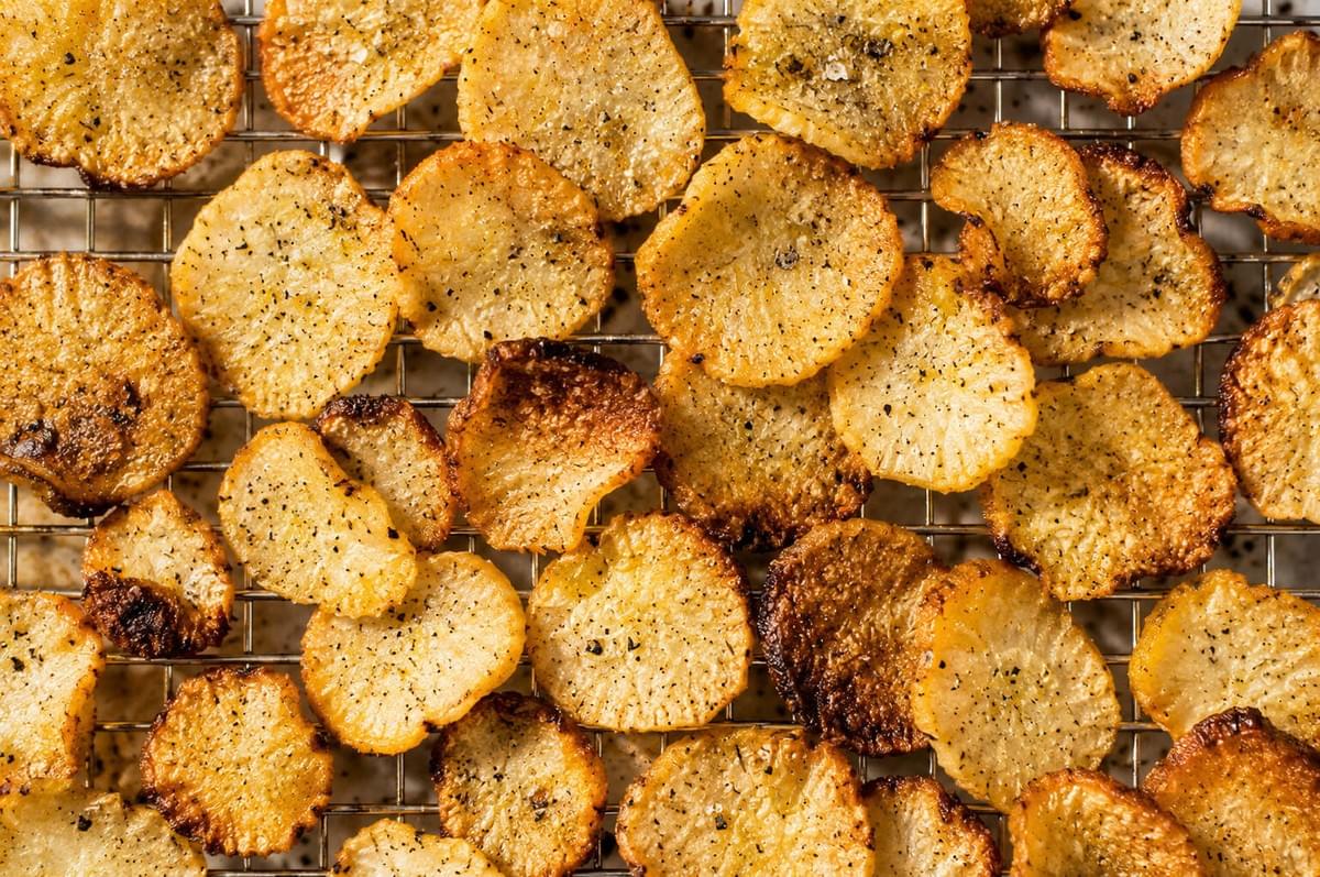 Golden, seasoned radish chips cooling on a wire rack.