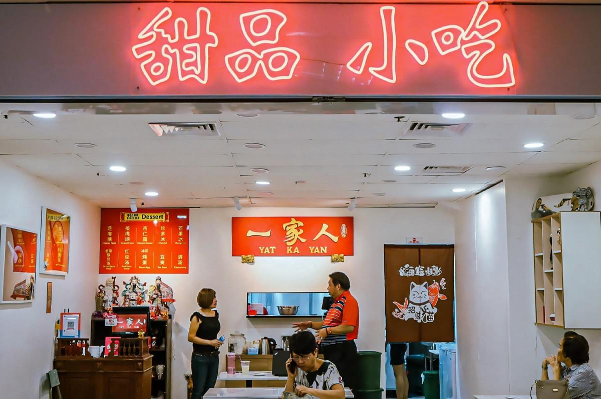 Front view of Yat Ka Yan Desserts at Fortune Centre, featuring bright red signage, Chinese décor, and customers ordering at the counter.