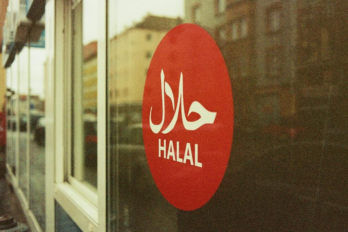 Halal certification logo displayed on a glass window.