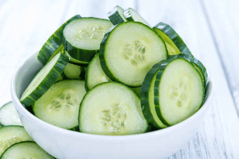 Elegant, thin ribbons of cucumber curled artistically on a serving plate, lightly dressed with a clear summer vinaigrette.
