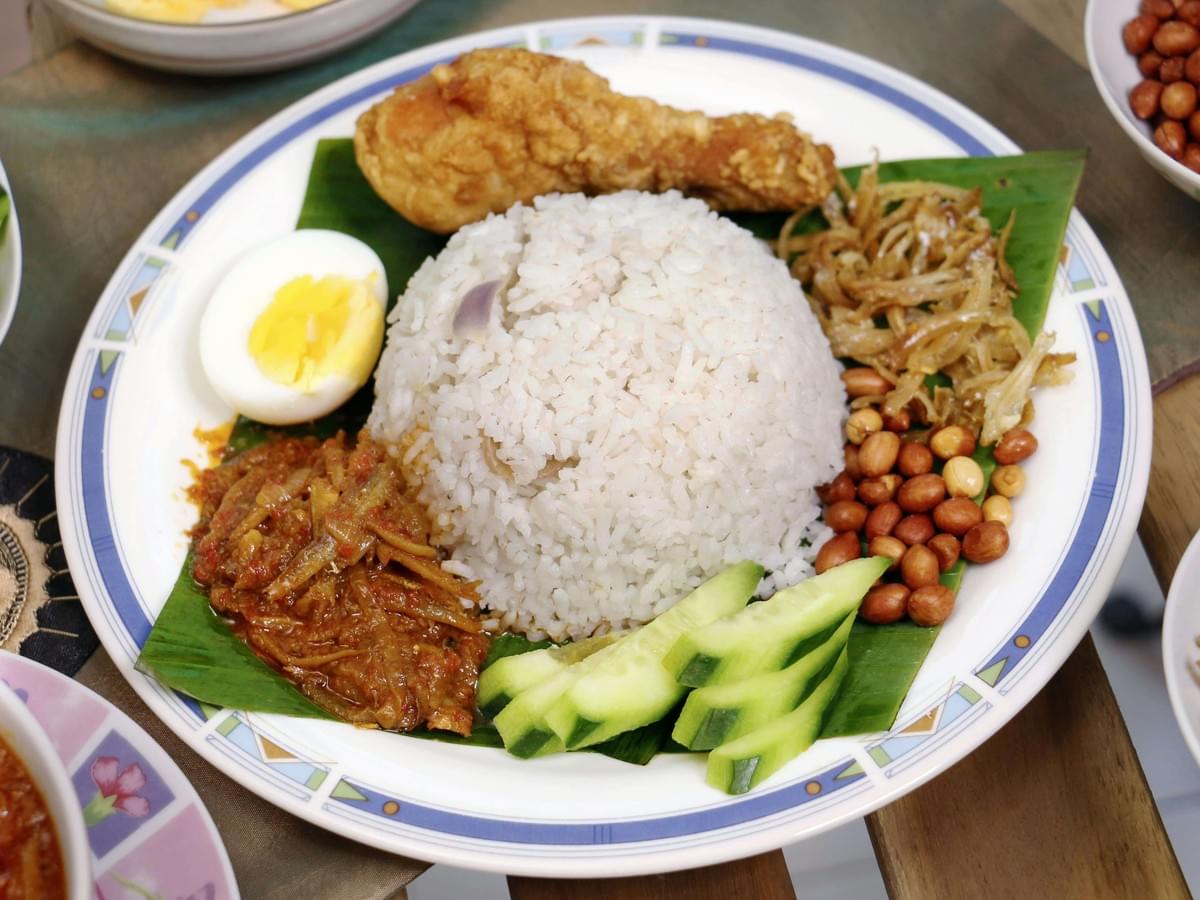 Nasi Lemak with all its delicious ingredients beautifully laid on a plate.