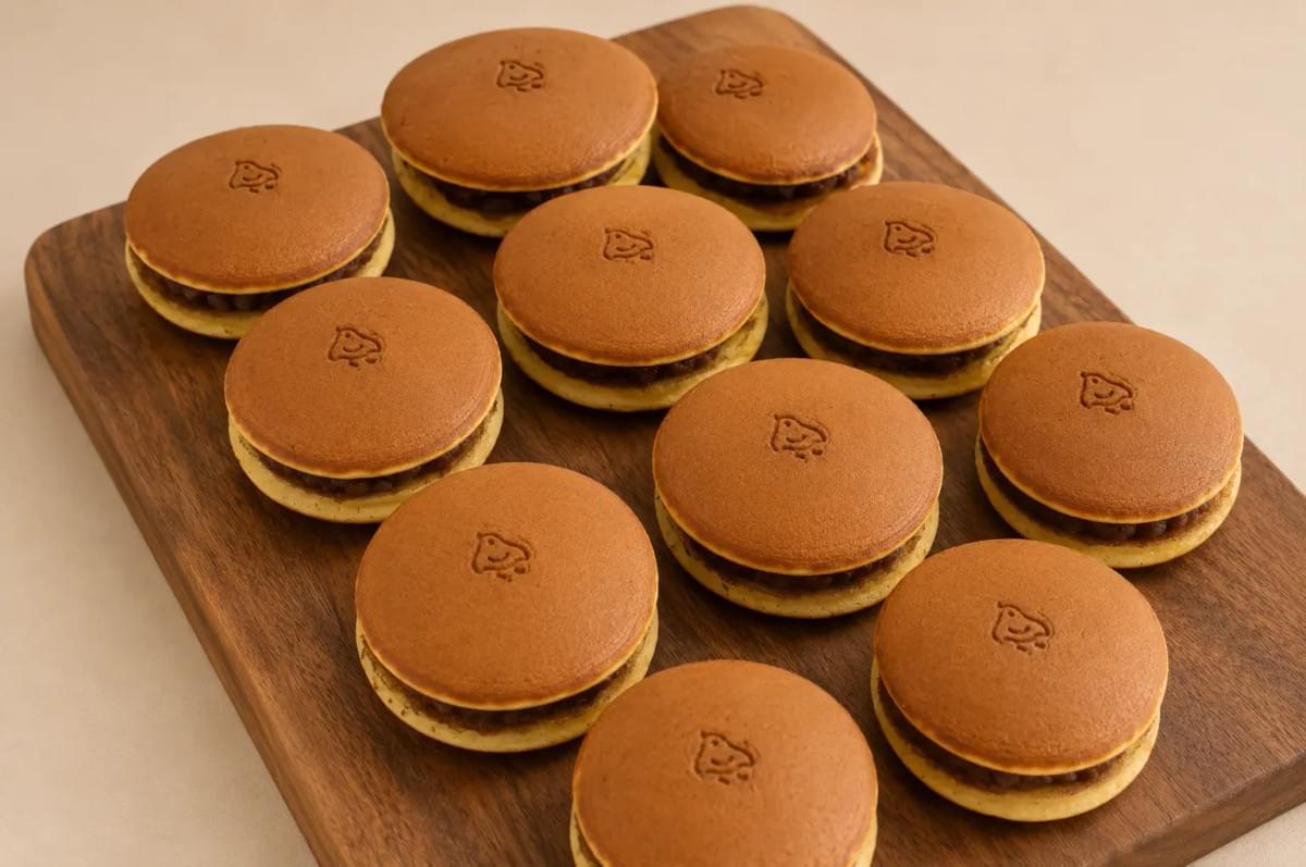 Traditional Japanese dorayaki filled with sweet red bean paste, displayed on a wooden board for dessert presentation.