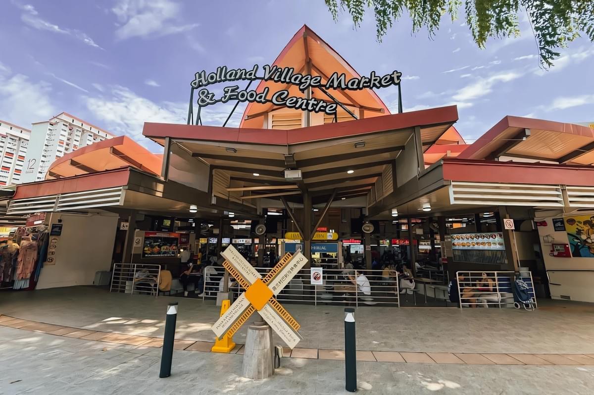 Front-facing exterior shot of Holland Village Market & Food Centre in Singapore, highlighting a popular local dining destination known for diverse food options and vibrant neighborhood atmosphere