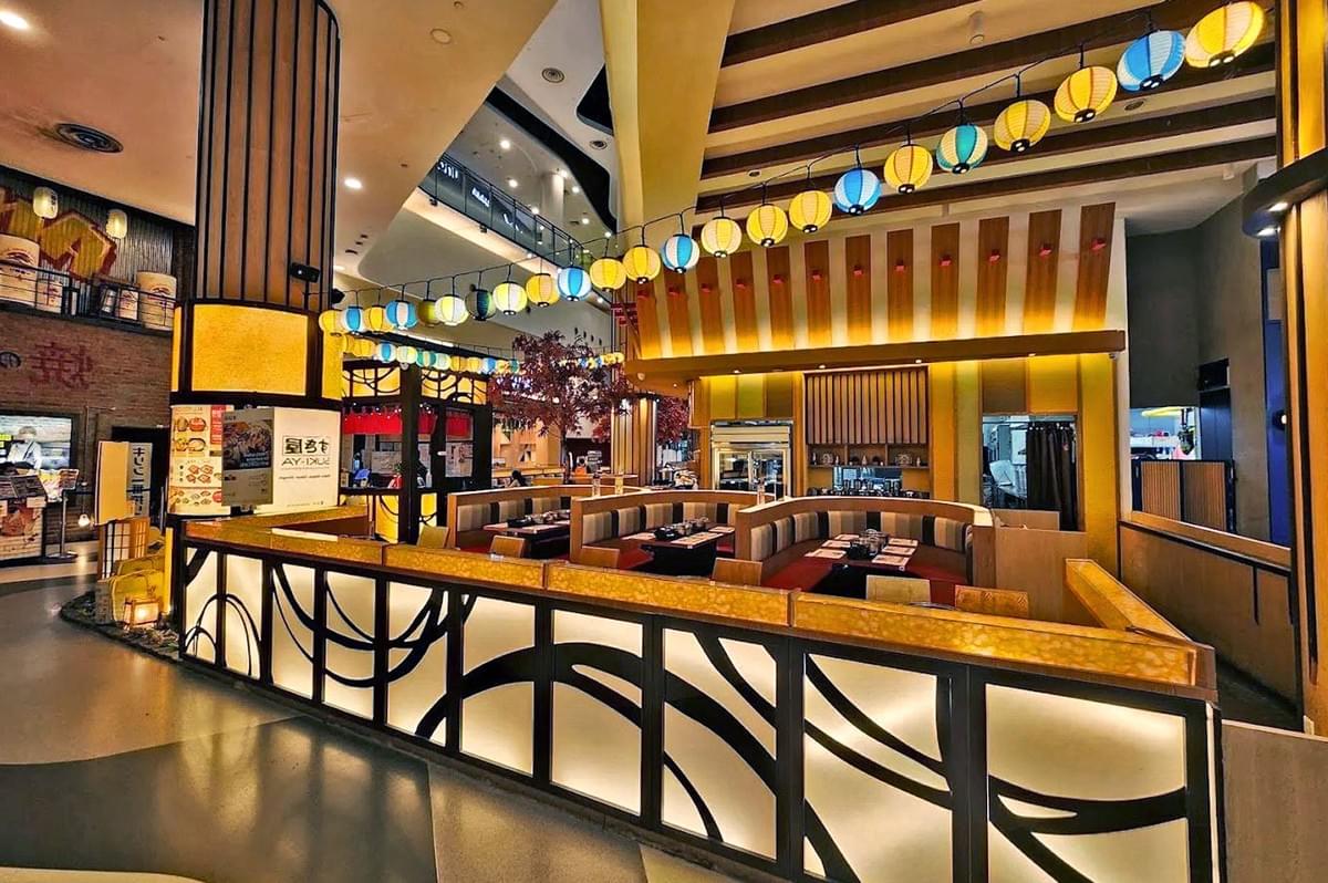 Stylish restaurant interior with warm lighting, colorful hanging lanterns, and semi-circular booths. Modern, inviting atmosphere with elegant decor.