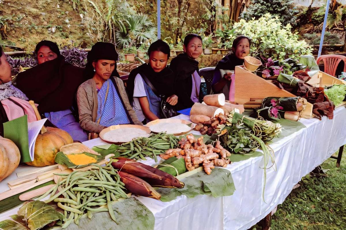 Display of fresh vegetables and roots at a market table.