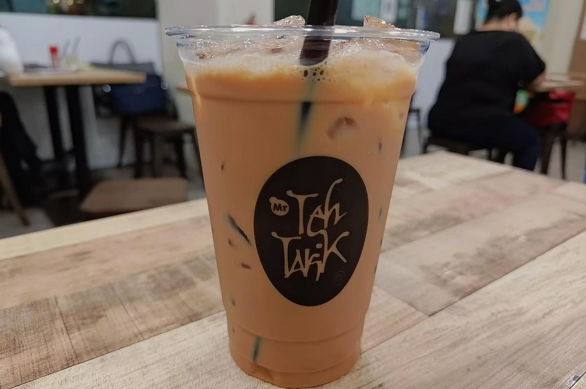 Iced coffee served in a cup on a table, showcasing Teh Tarik from Singapore.