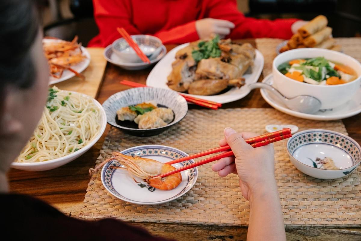 A table filled with traditional Indian festival foods, including sweets and savoury snacks arranged for a festive Deepavali meal.