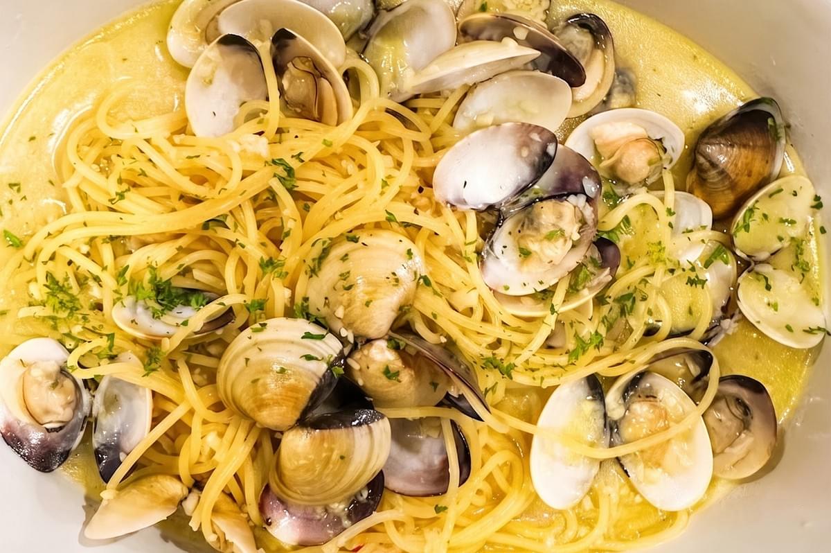 Close-up view of spaghetti alle vongole, a classic Italian pasta dish with fresh clams, garlic, and parsley in a light sauce.
