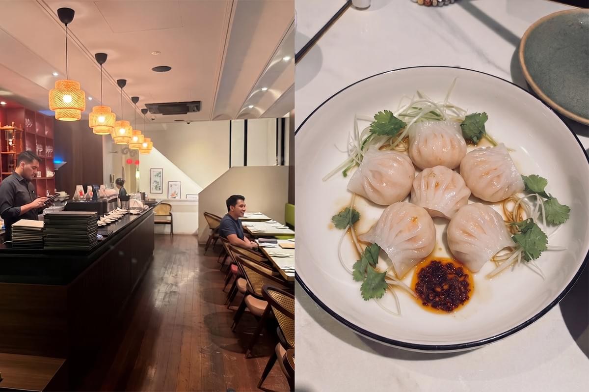 Freshly steamed Loong Dim Sum dumplings on a plate with chili oil and herbs, set inside a contemporary dining room.