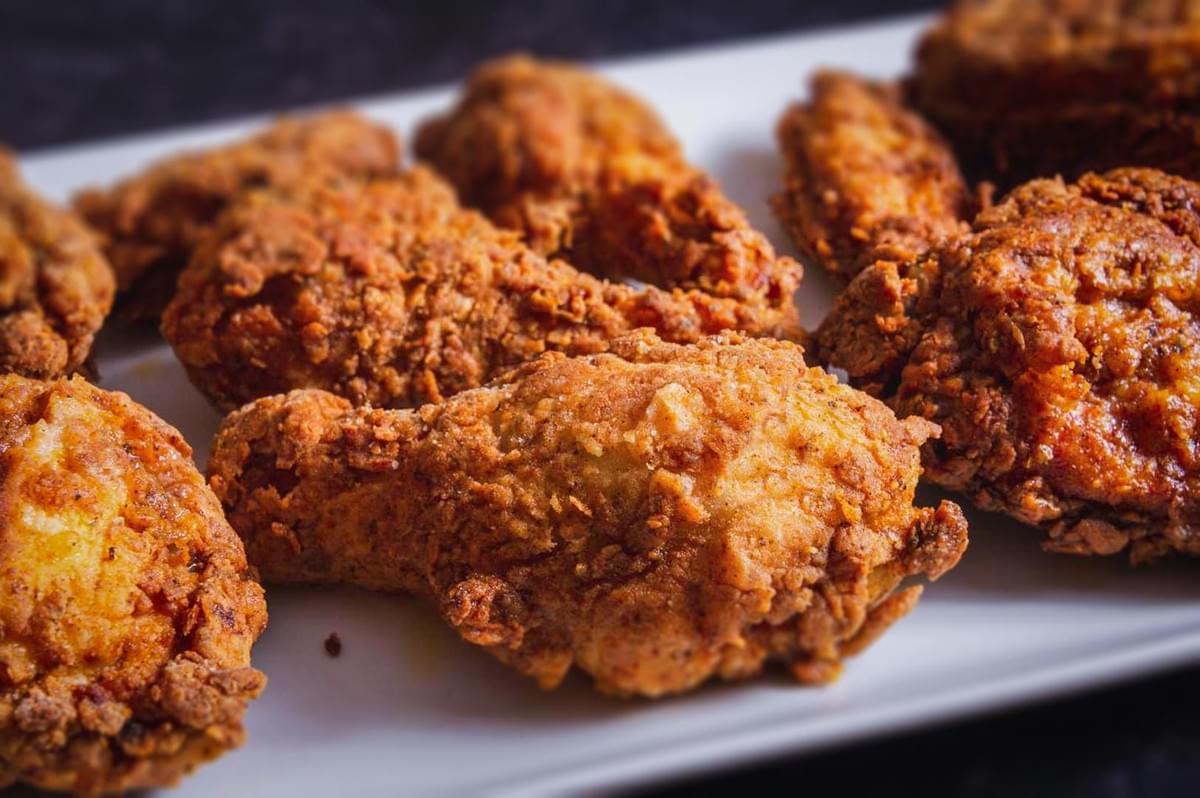 Crispy Southern fried chicken drumsticks arranged on a serving platter.