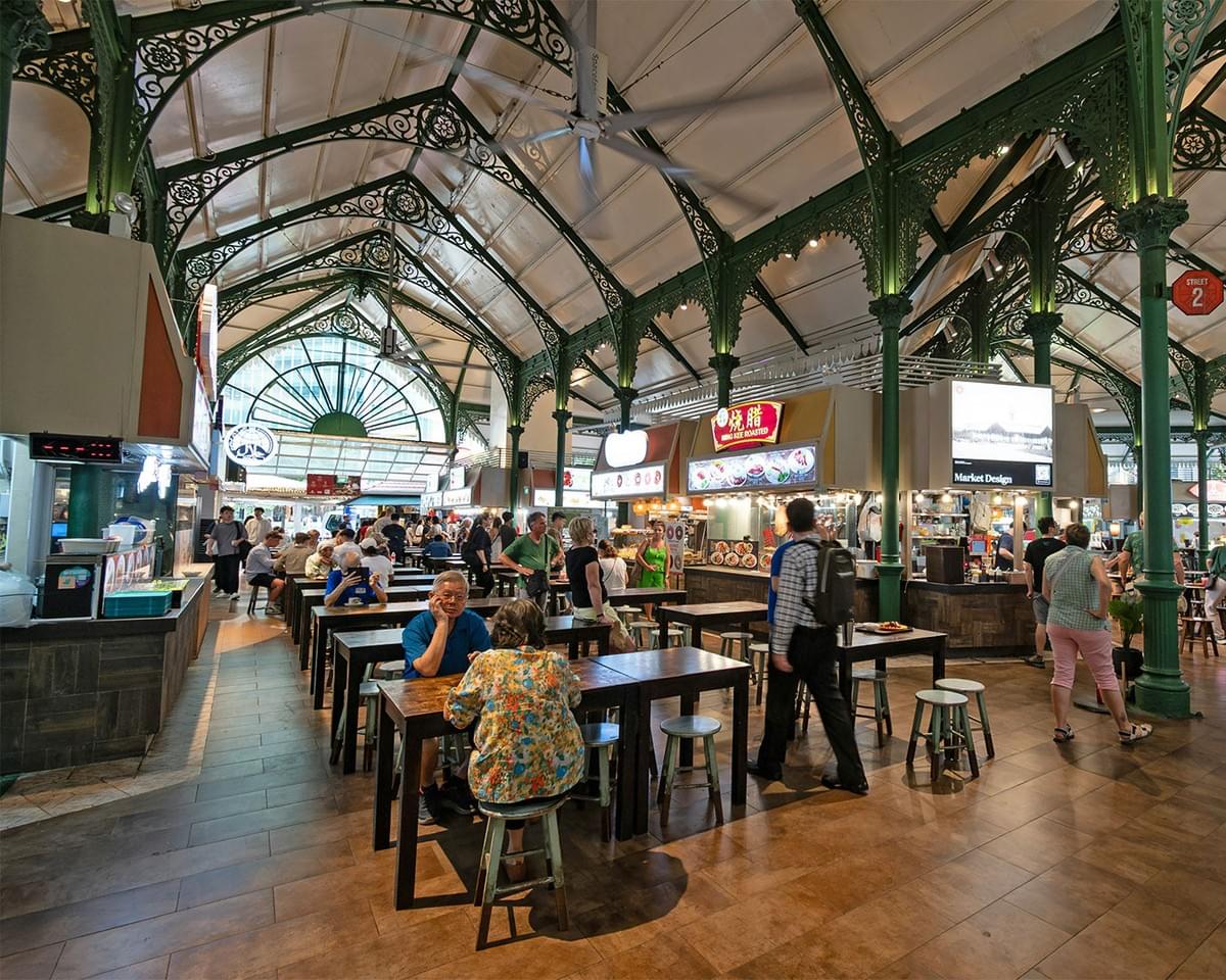 A busy hawker centre filled with diners enjoying their meals, capturing the lively atmosphere of Singapore’s street food culture.