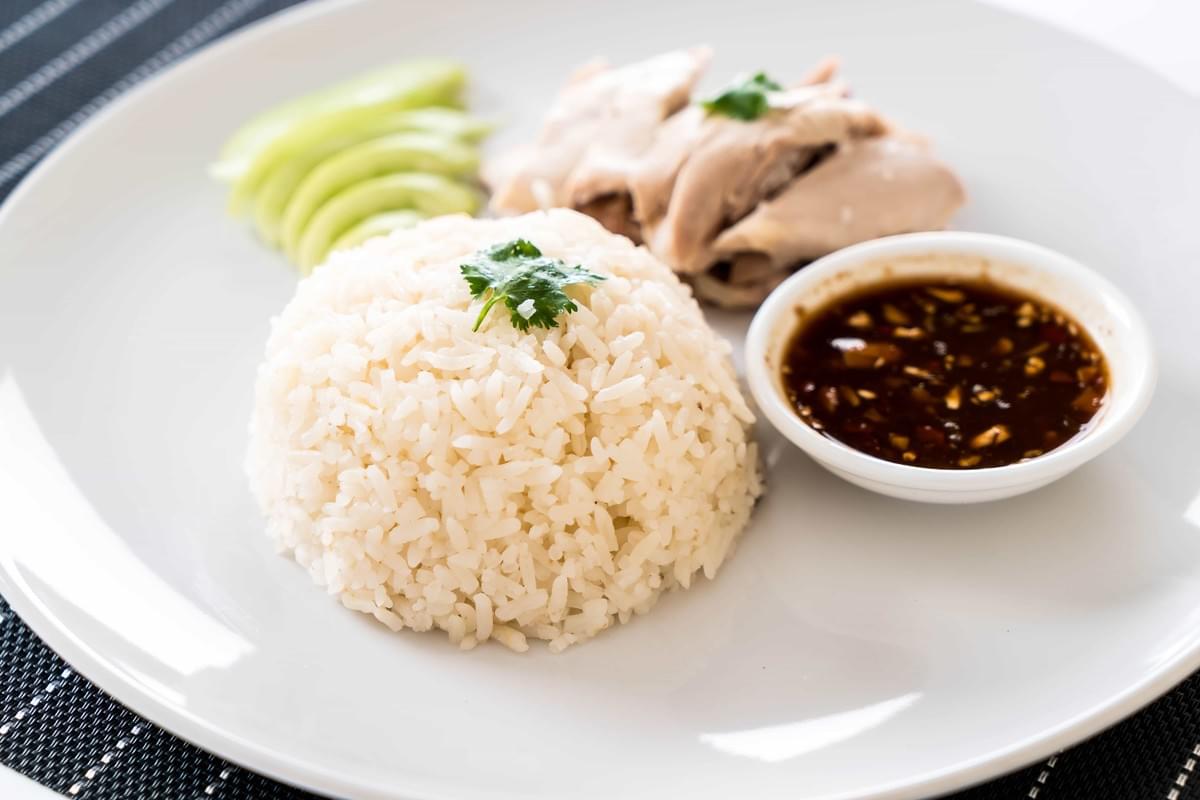 A Hainanese chicken rice, coupled with its sauces and side dishes.