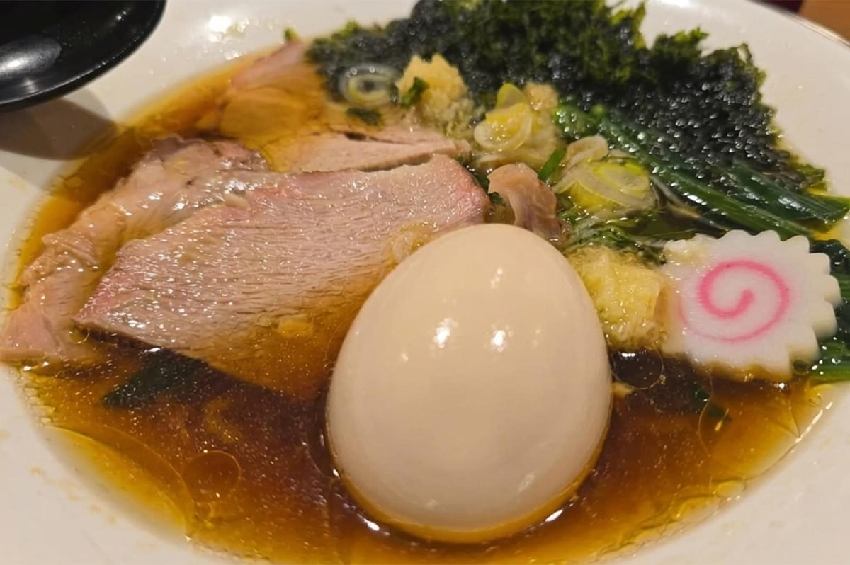 A bowl of soup with meat and egg.