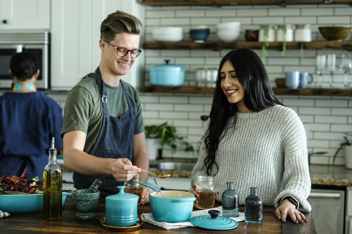 In a kitchen, a man and woman collaborate on meal preparation, showcasing the therapeutic advantages of cooking together.