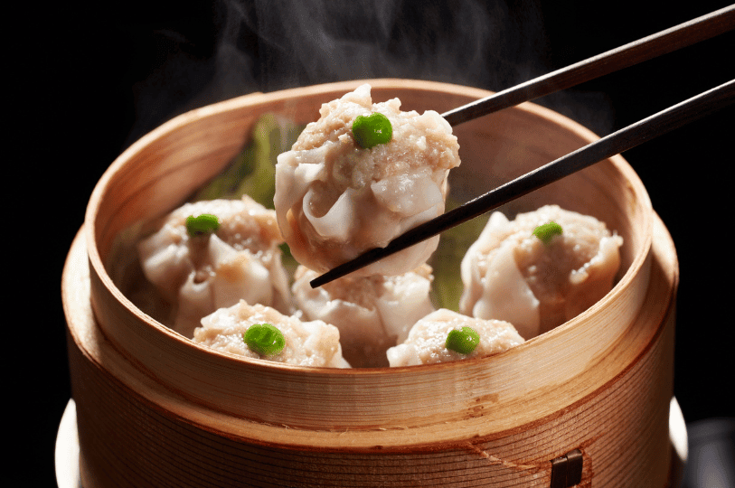 A bamboo steamer filled with freshly steamed shumai, one lifted by chopsticks to reveal its savory filling and rising steam—capturing the warmth and artistry of Chinese dim sum on the global dumpling trail.