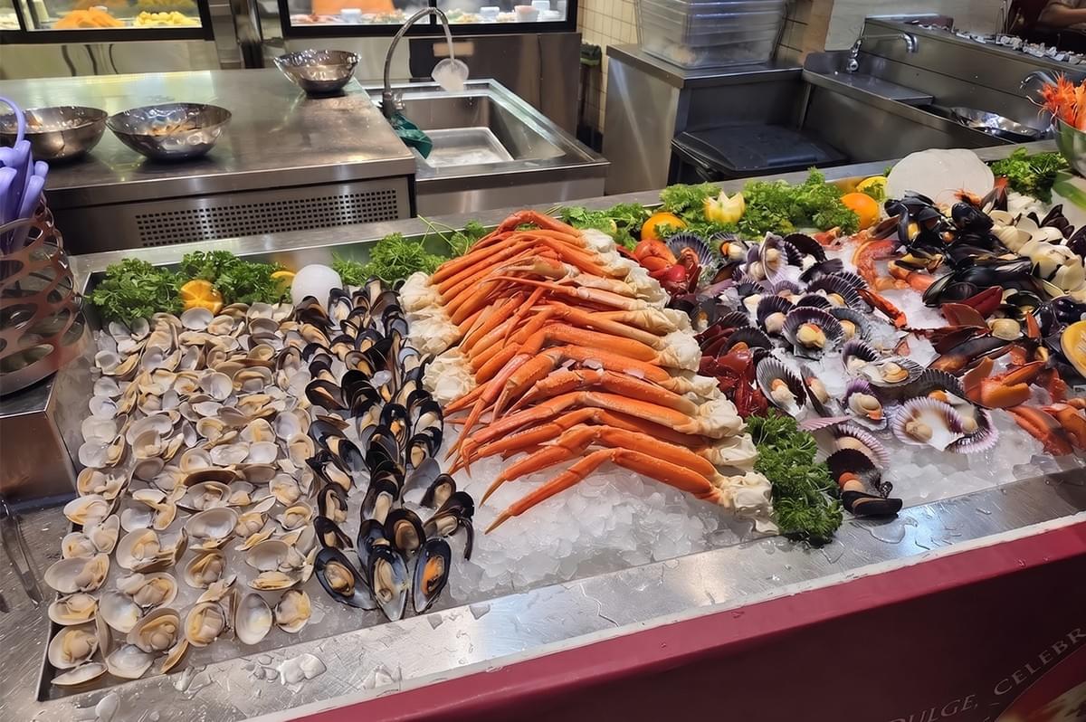 Fresh seafood buffet display with crabs, clams, and mussels on ice at Carousel restaurant.