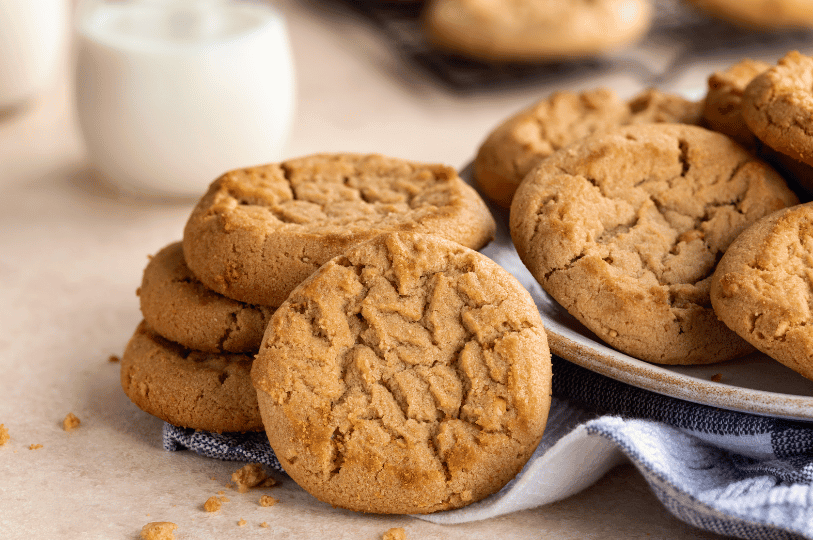 A row of peanut butter cookies lined up on parchment paper, ready to be served, illustrating a successful batch of quick and easy homemade treats.