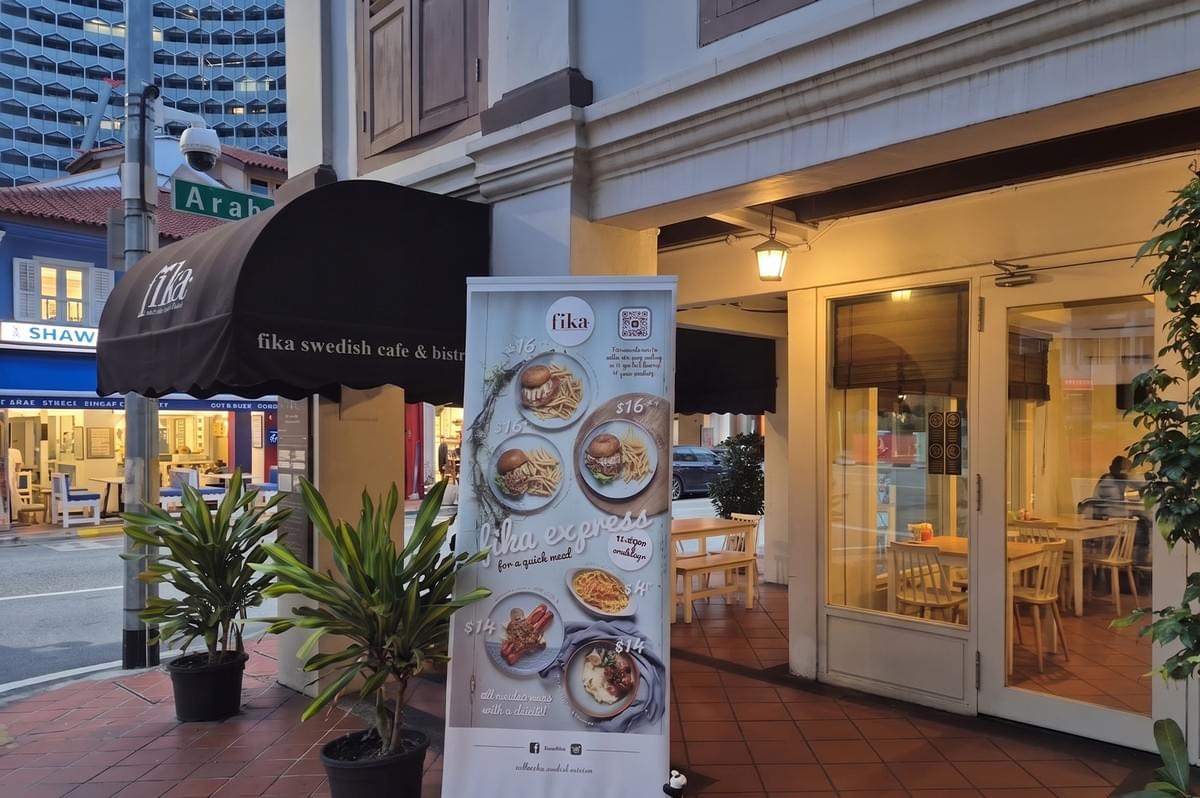 Exterior of Fika Swedish Cafe & Bistro, showing a promotional menu stand for "Fika Express" quick meals.