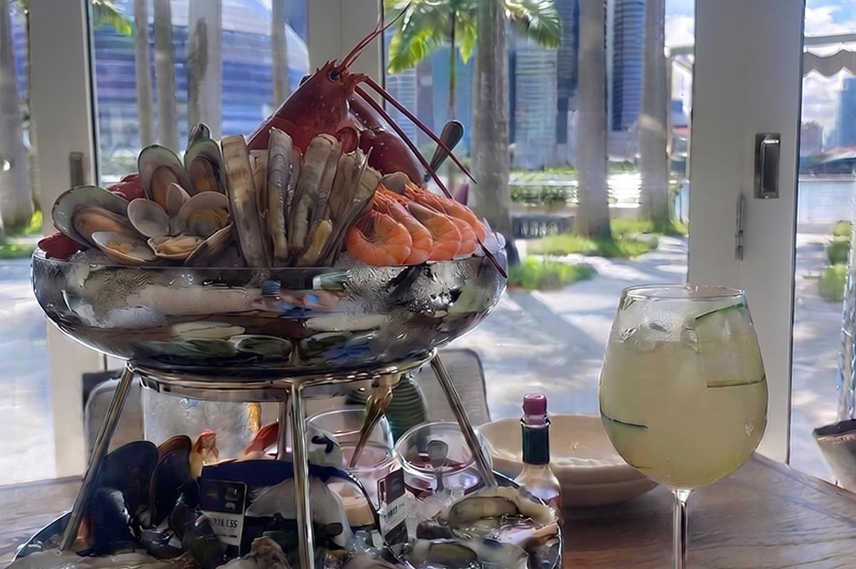 Fresh seafood tower with lobster, shrimp, mussels, and clams at Maison Boulud overlooking Marina Bay Sands in Singapore.