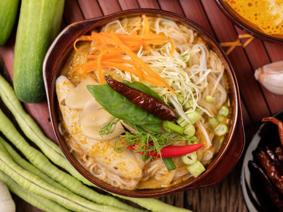 Singapore Laksa, surrounded by its ingredients and its beauty in full display.
