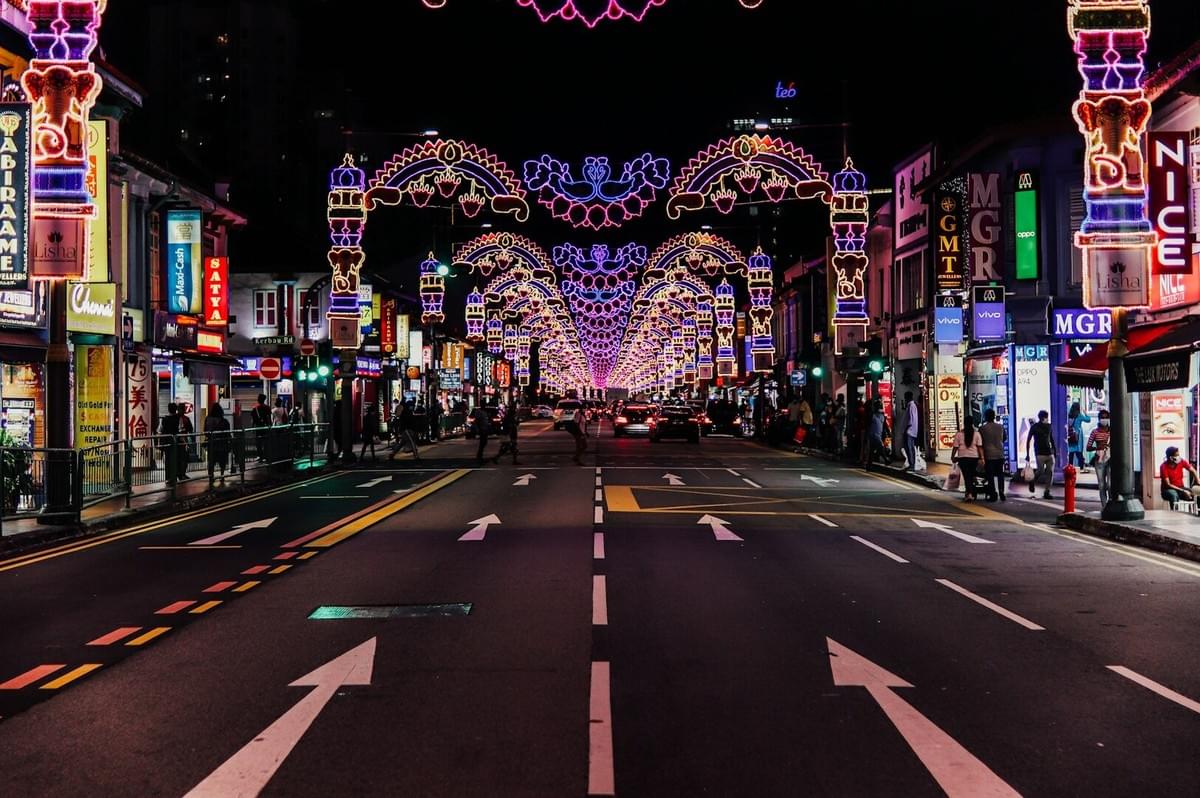 A lively street scene with bright lights and crowds, showcasing the vibrant nightlife and hidden culinary treasures of Singapore.