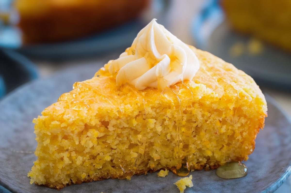 Moist slice of homemade Southern cornbread topped with butter and drizzled with honey.
