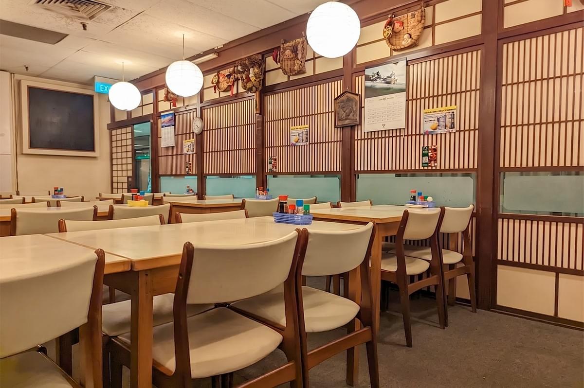 Cozy dining room and bar seating area inside Izakaya Nijumaru Japanese restaurant.