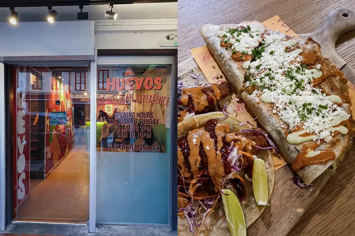 Left: An eye-level, medium shot of the storefront entry to 'Huevos The Mexican Experience', featuring a glass door, track spotlighting, a wooden floor interior pathway, and window text displaying opening hours. Right: A three-quarter, close-up food shot on a wooden board presenting two tacos drizzled with orange sauce and garnished with red cabbage and lime wedges alongside a large, folded quesadilla topped with crumbled white cotija cheese, light green crema, and chopped chives.