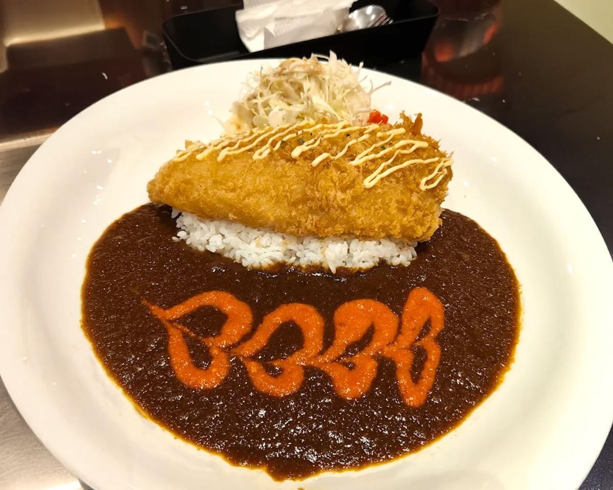 A hearty serving of Monster Curry Japanese curry featuring a generous portion of rice and spicy curry sauce, topped with crunchy tempura and vegetables.