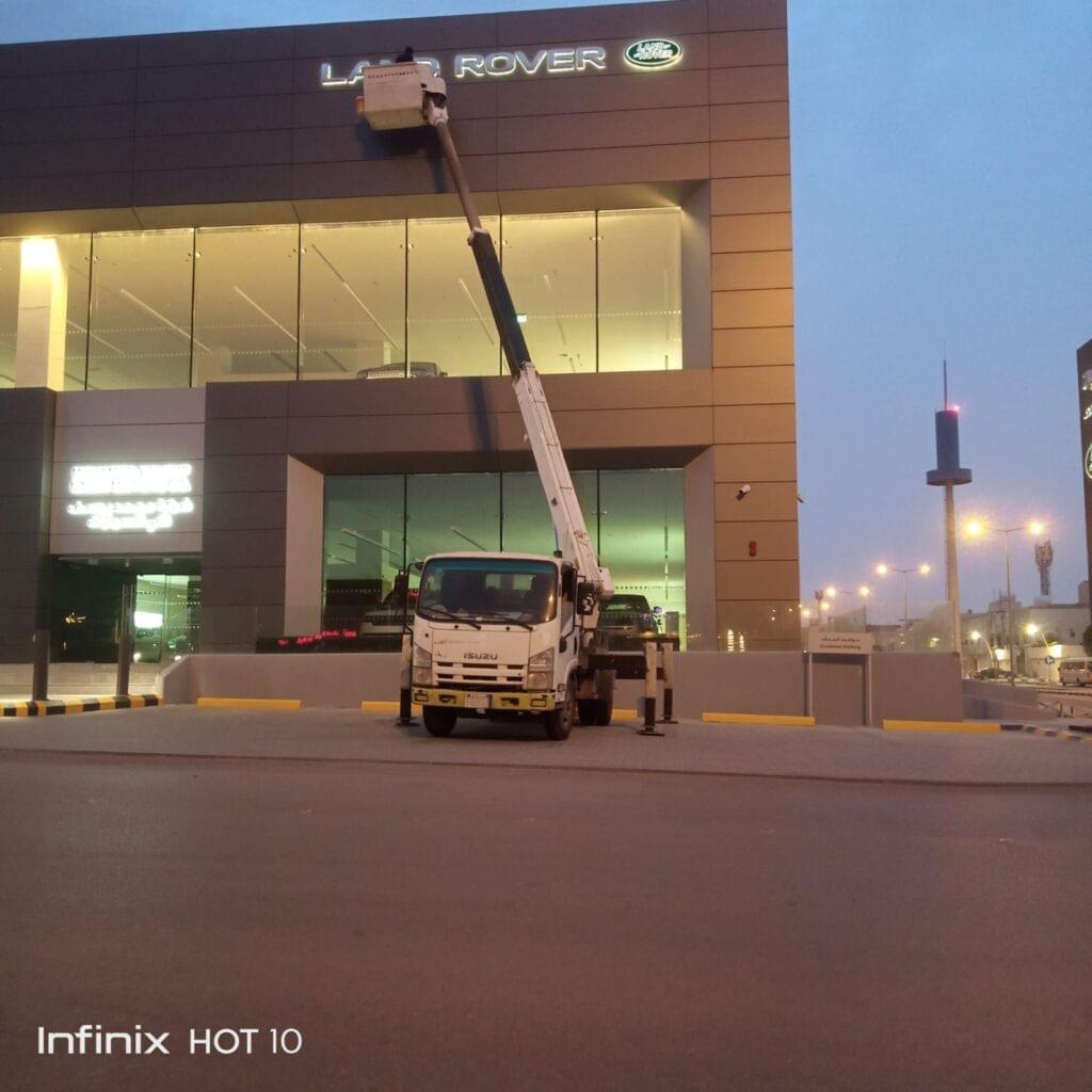 فريق من العاملين شركة تنظيف زجاج محلات و مكاتب يهتمون بتنظيف الزجاج  بواسطة رافعة حديثة بمدينة الرياض