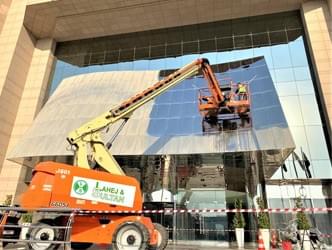 alt="فريق عمل أفضل تنظيف واجهات المباني في الرياض ينظف واجهة زجاجية في الرياض"