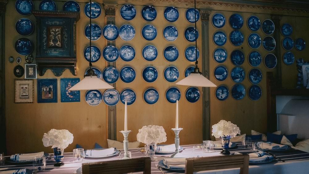 Gedeckter Tisch mit blauer Teller-Dekoration an der Wand