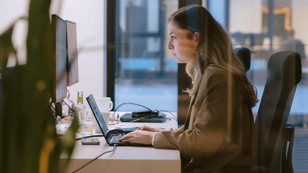 Eine junge Frau arbeitet am Laptop