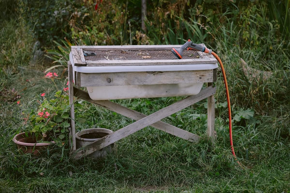 Ein Pflanztisch im Garten mit einem Wasserschlauch